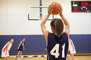 High school girl shooting a basket during a basketball game.